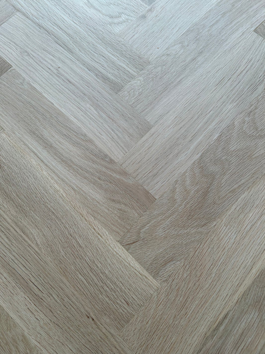 Close-up of a gray wood floor with a herringbone pattern